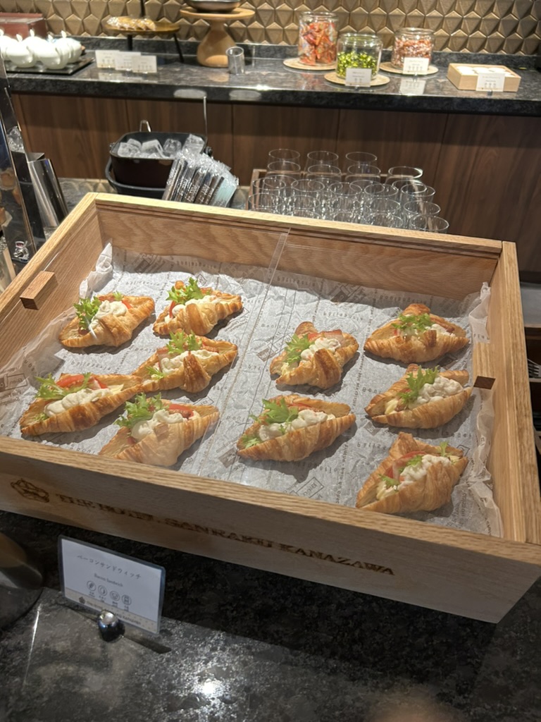 カクテルタイムに提供される軽食のパイ。THE HOTEL SANRAKU KANAZAWAのロゴ入りの木箱に盛り付けられている